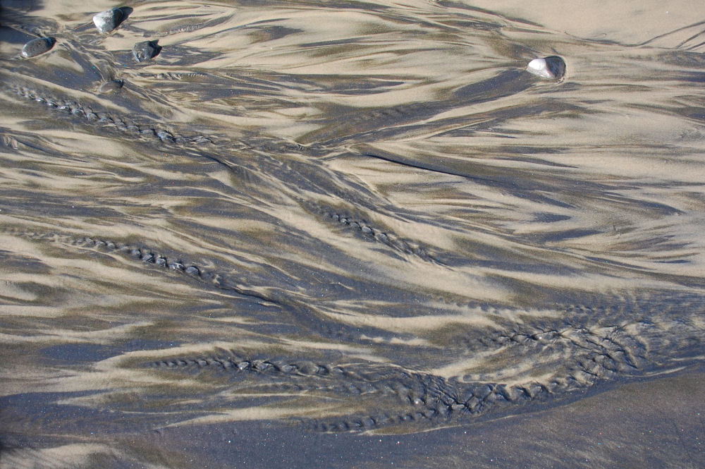 Streams of water washing down to the ocean and and black sand designs, Oceanside, OR beach Streams of water washing down to the ocean and and black sand designs, Oceanside, OR beach